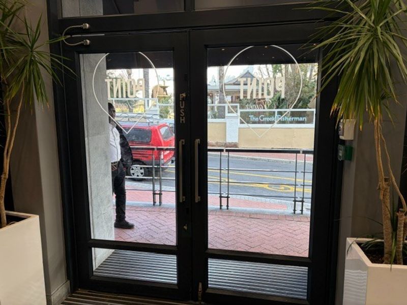 A modern glass-paneled double door entrance providing access to the office premises, featuring clean lines and professional hardware.