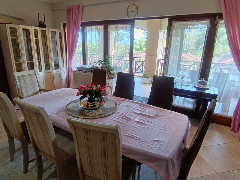 Dining room featuring tiled flooring and large sliding glass doors that provide access to an outdoor patio area.