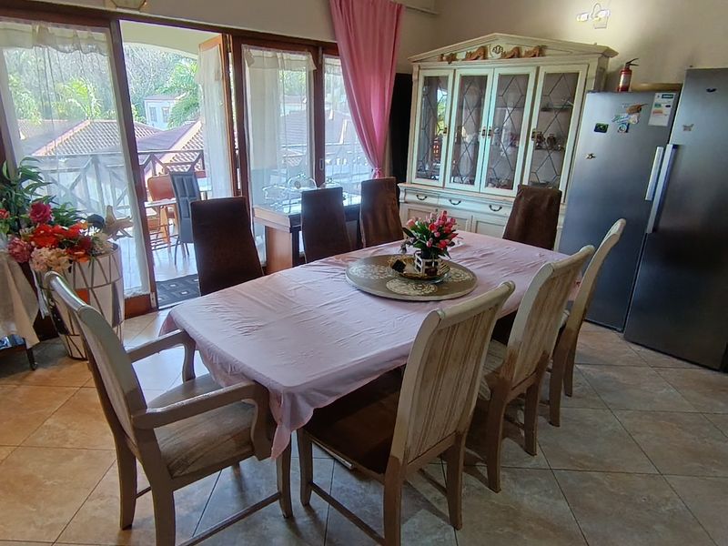 Dining area featuring tiled flooring and large sliding glass doors providing access to an outdoor balcony space.