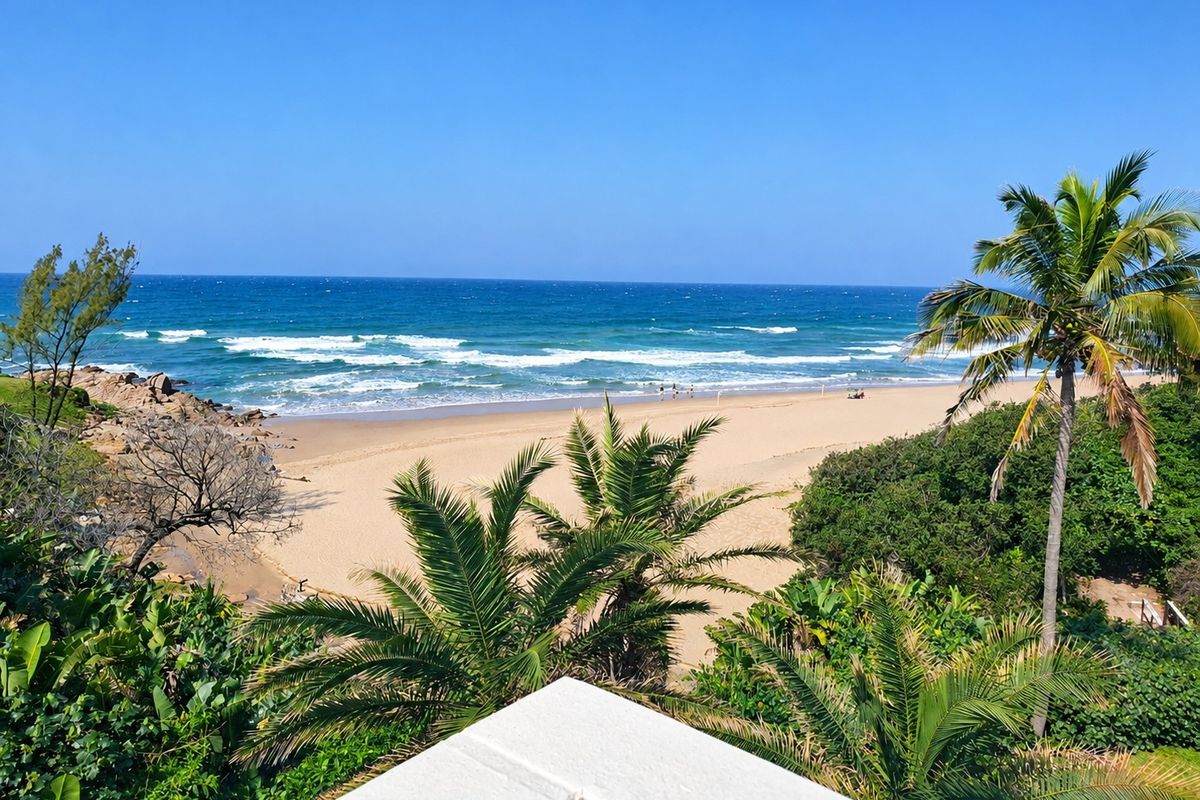 A scenic elevated view overlooking a sandy beach, ocean waves, and lush coastal vegetation.