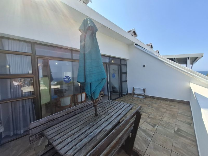 A spacious balcony featuring tiled flooring and large sliding glass doors, providing seamless indoor-outdoor flow and access to the apartment interior.
