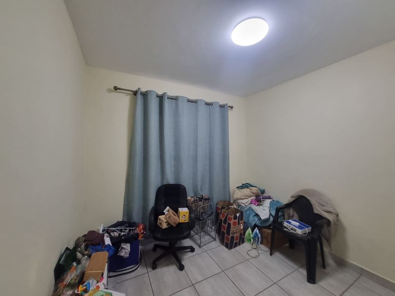 A functional bedroom space featuring tiled flooring and a curtain rod, offering a blank canvas for personalization.