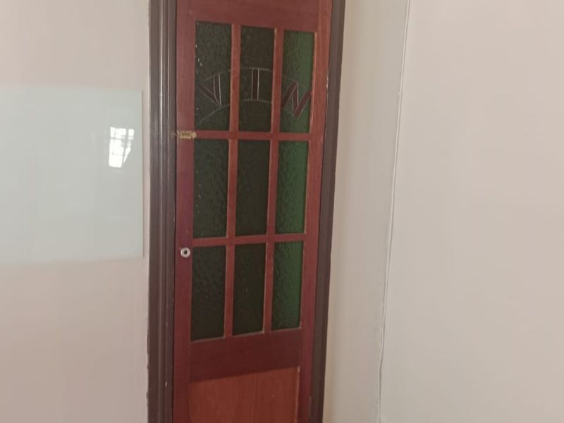 A view of a traditional timber-framed glass door set within a hallway, featuring classic architectural detailing.