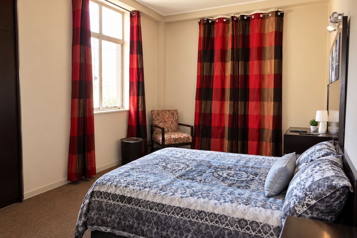 A bedroom featuring carpet flooring, a built-in wardrobe, and a window with natural light.