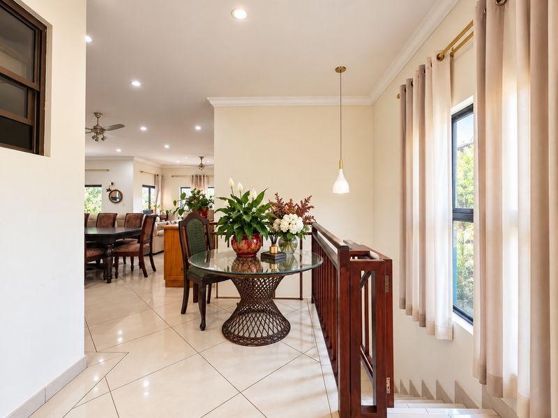 A bright landing area featuring tiled flooring, a timber balustrade, and recessed lighting, providing an open transition to the main living space.