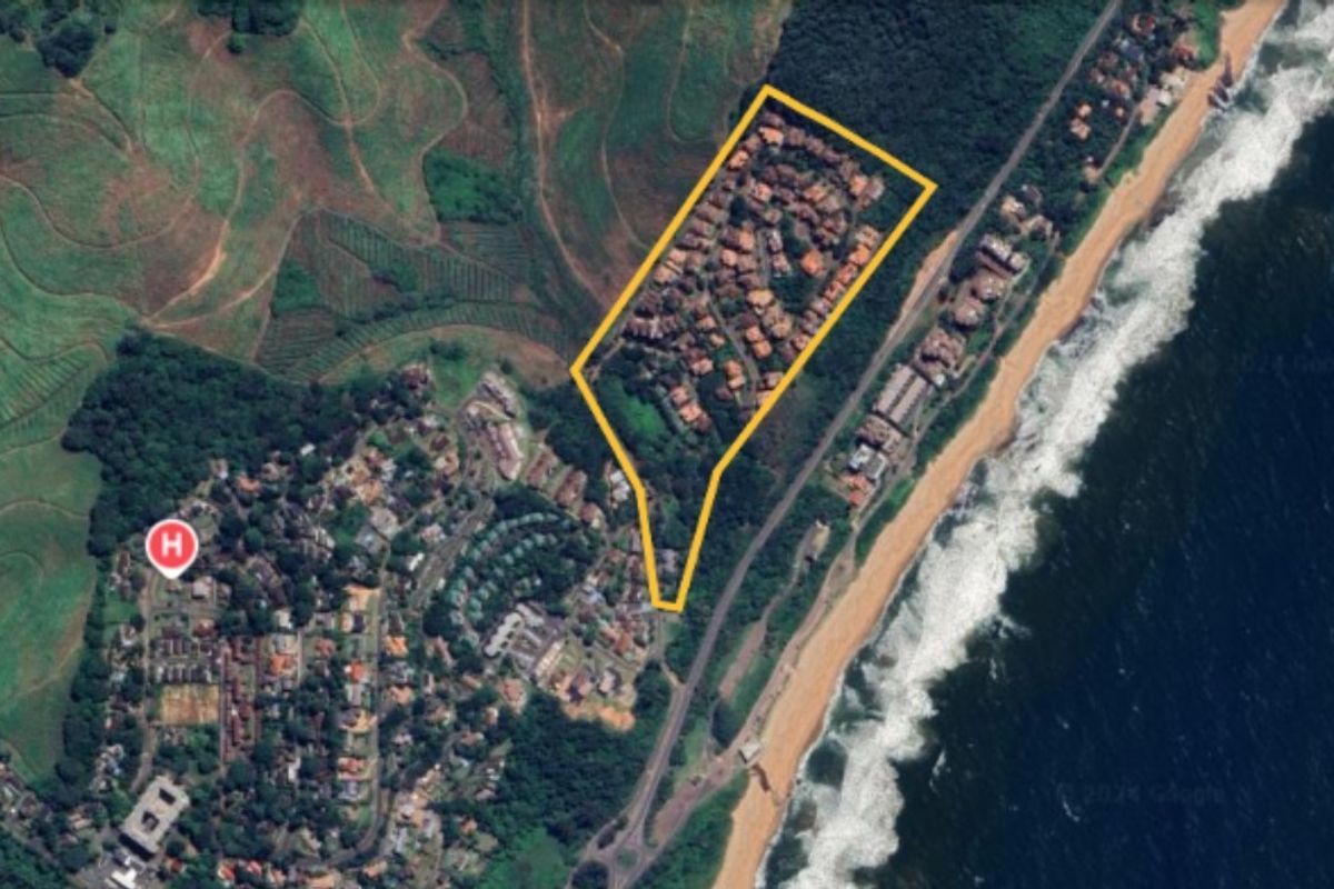 Aerial view of a coastal residential estate, highlighting its proximity to the beach and surrounding landscape.