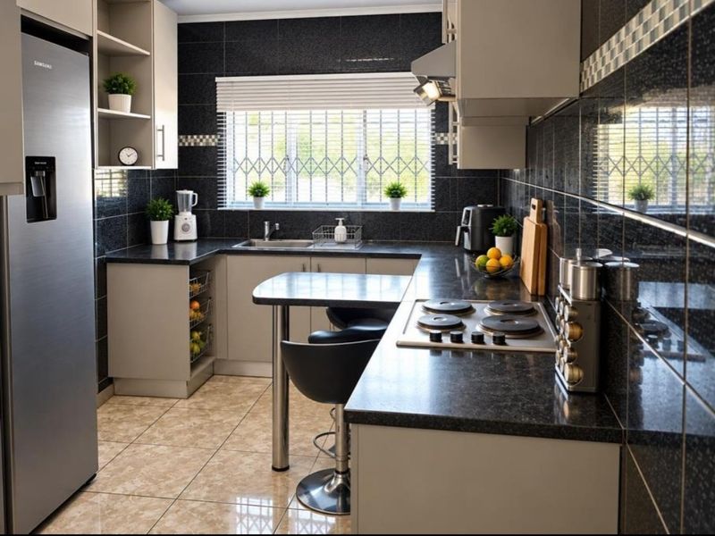 Modern kitchen featuring dark granite countertops, sleek cabinetry, integrated electric hob, extractor fan, and tiled finishes with a functional breakfast nook.
