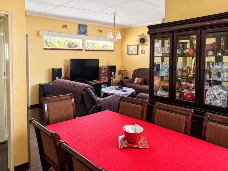 Open plan living and dining area featuring tiled flooring, a drop ceiling, and clerestory windows providing natural light.