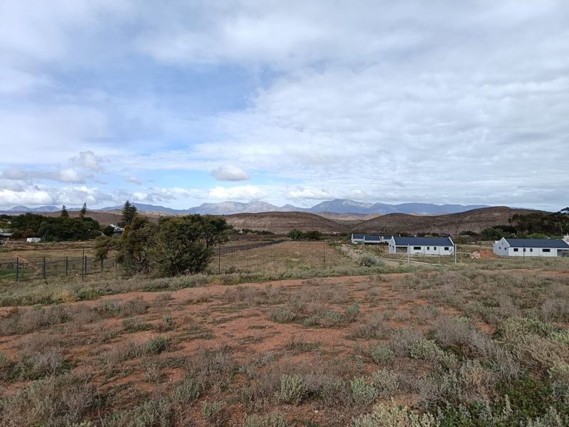 A scenic view of the surrounding landscape and mountain range from the vacant residential property.