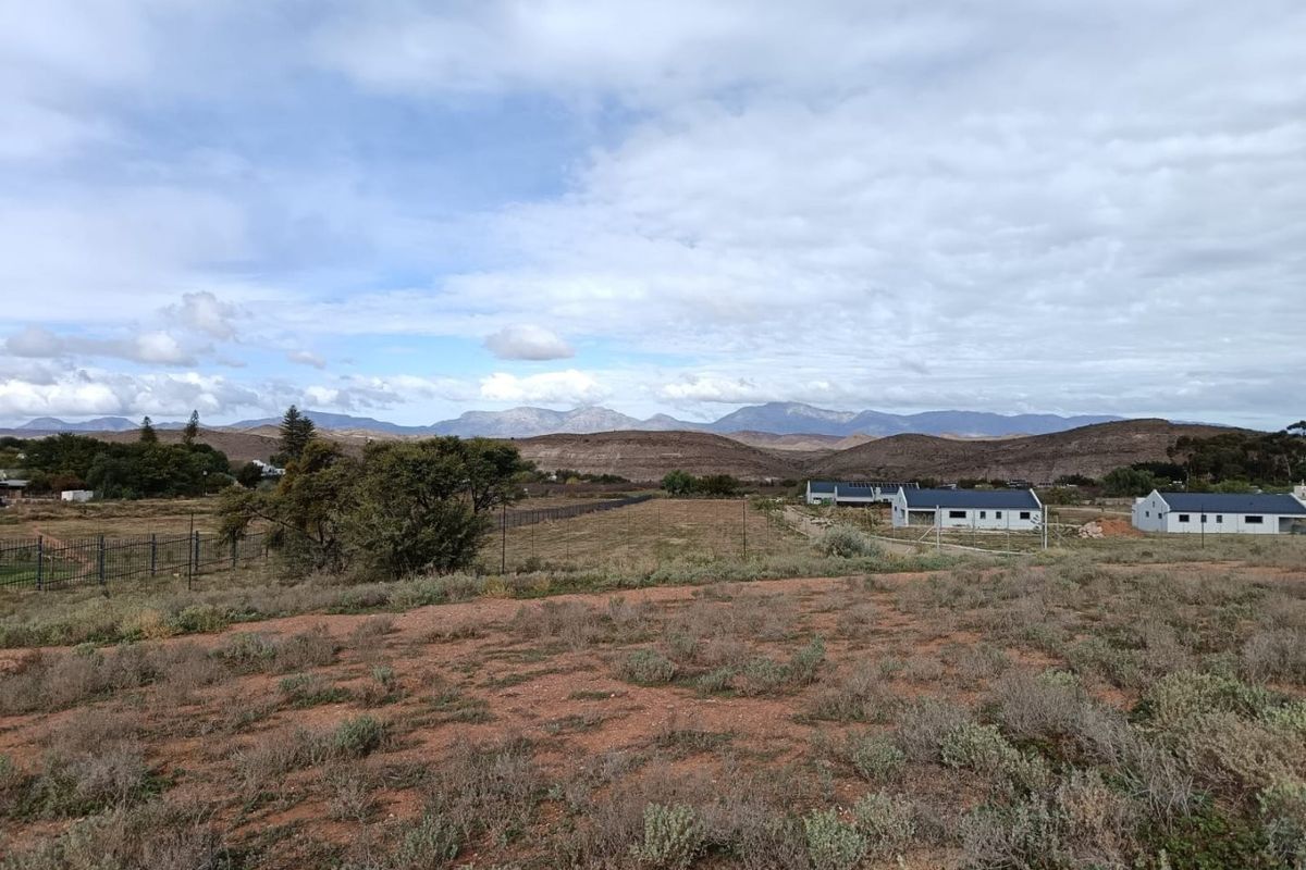 A scenic view of the surrounding landscape and mountain range from the vacant residential property.