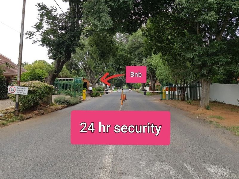 Street view of the property entrance featuring a 24-hour security boom gate and controlled access point.