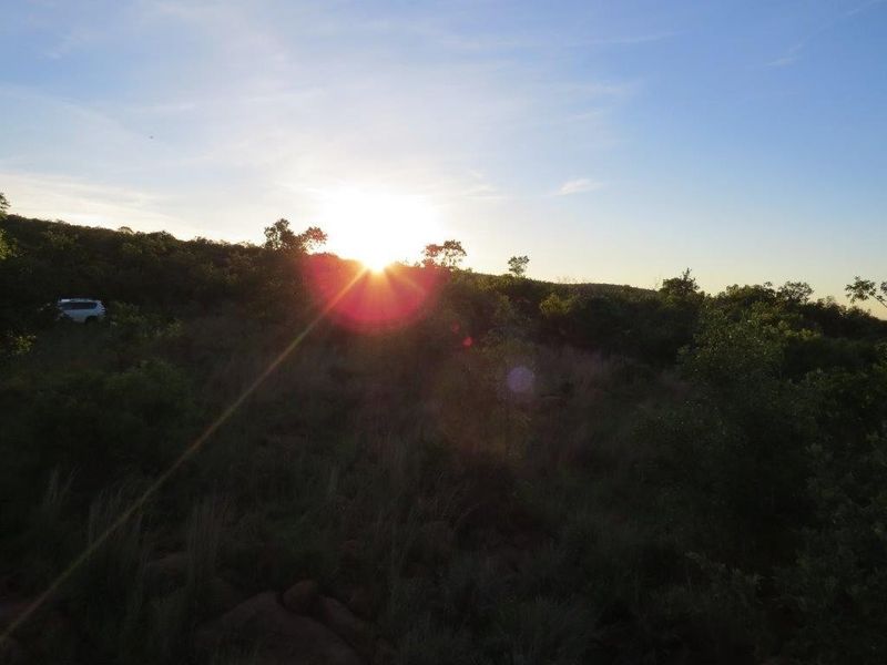 A scenic view of the natural landscape at sunset, showcasing the undeveloped terrain of the residential vacant land.