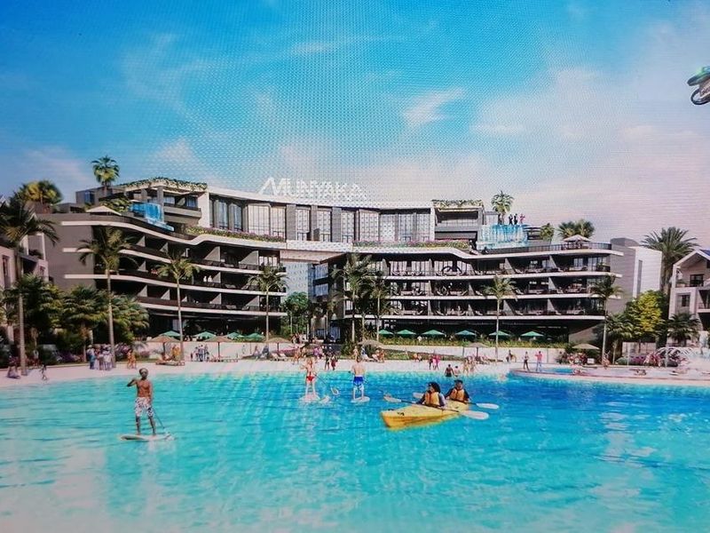 A wide-angle view of a large residential apartment complex featuring a central swimming pool and recreational water area.