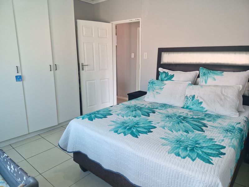 A functional bedroom featuring tiled flooring and built-in cupboards, providing ample storage space.