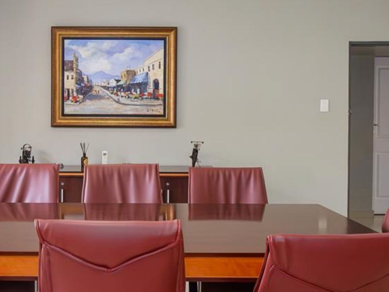 A formal dining room featuring neutral wall tones and a doorway leading to an adjacent space.
