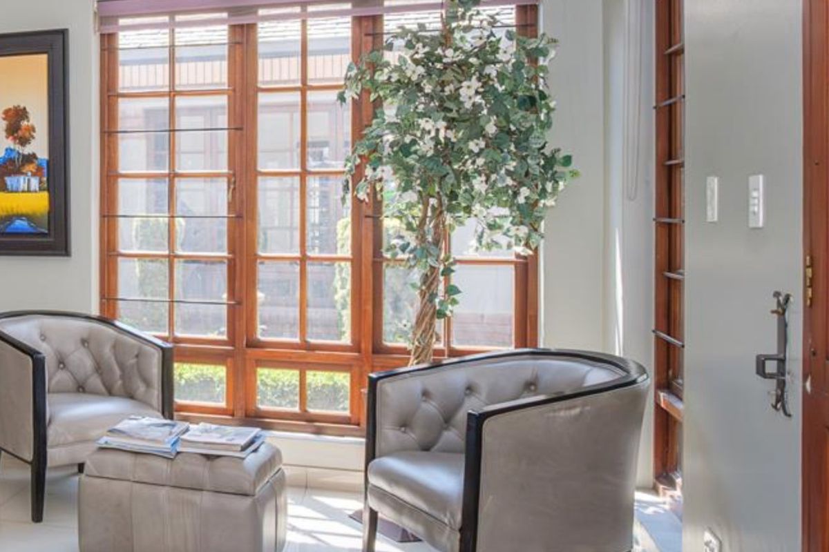 A bright living area featuring large timber-framed windows that provide natural light and a view of the exterior.