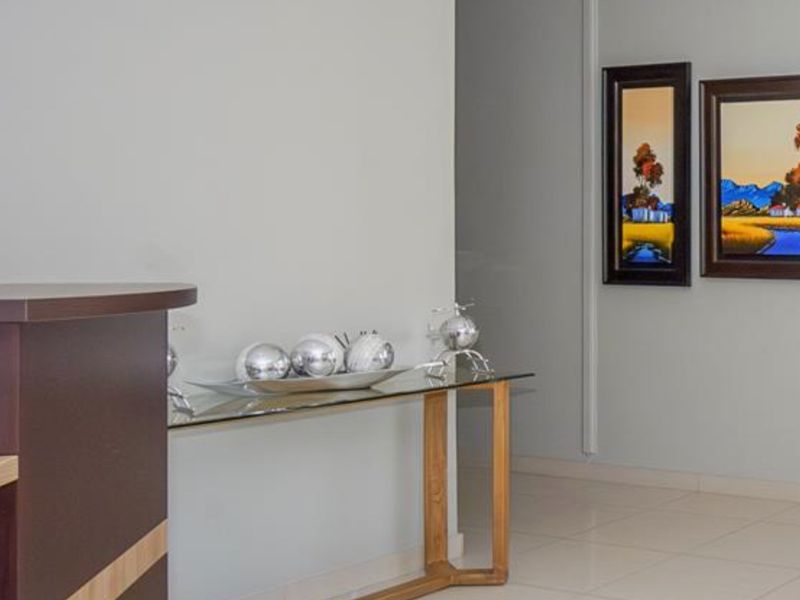 A clean and well-maintained hallway featuring neutral tiled flooring and smooth wall finishes, providing a bright and welcoming transition space within the home.