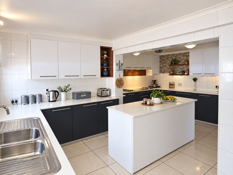 Modern kitchen featuring a central island, white and dark cabinetry, quartz countertops, tiled backsplash, and high-quality finishes throughout.