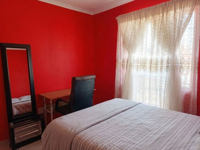 A bedroom featuring tiled flooring and cove cornicing, currently finished with bold red wall paint.