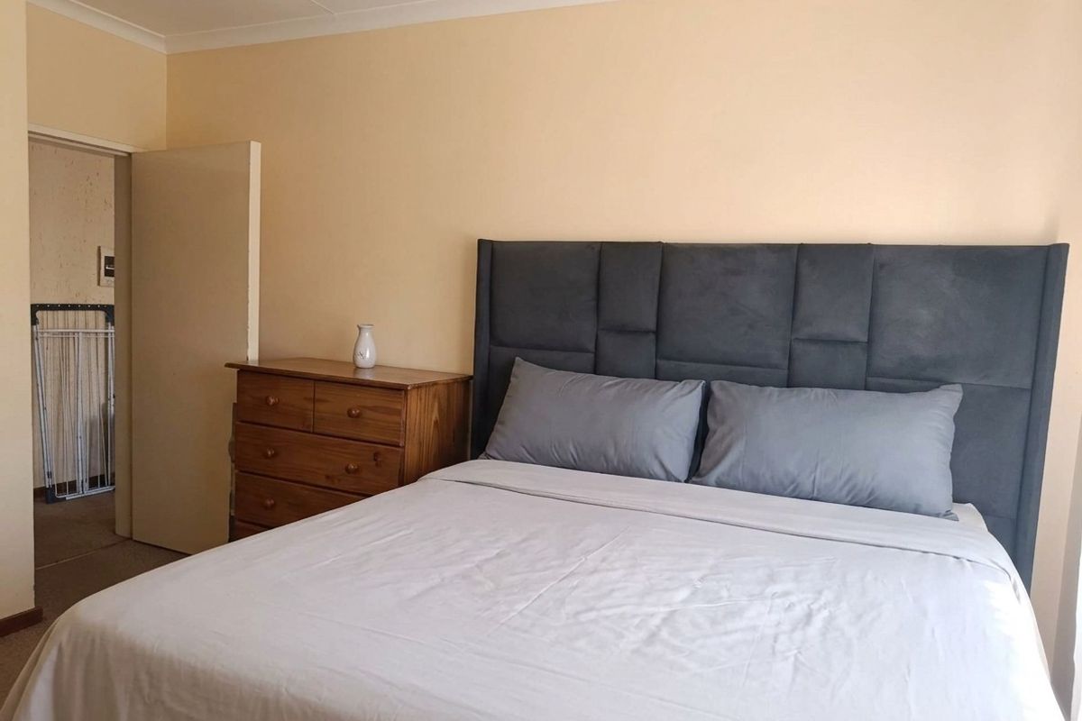 A standard bedroom featuring neutral wall paint and coving, providing a functional and well-lit sleeping space.