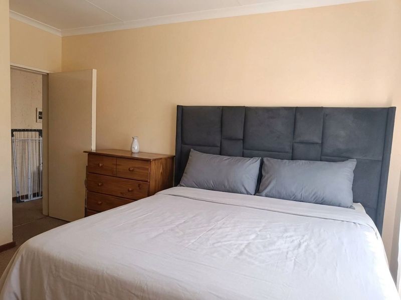 A standard bedroom featuring neutral wall paint and coving, providing a functional and well-lit sleeping space.