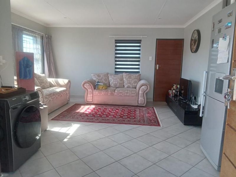 Open plan living area featuring tiled flooring and neutral wall finishes, providing a functional space for daily living.