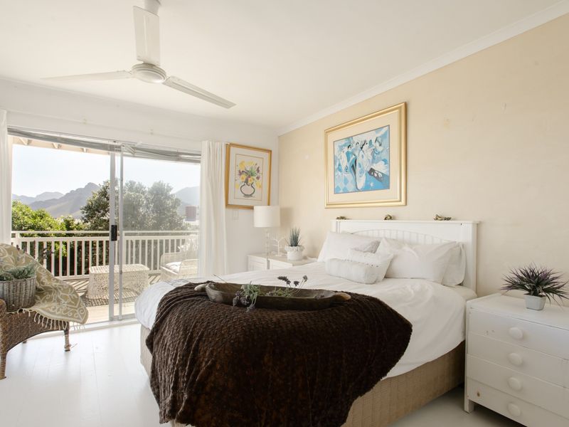 Bright bedroom featuring a ceiling fan and sliding glass doors that open onto a private balcony with scenic views.