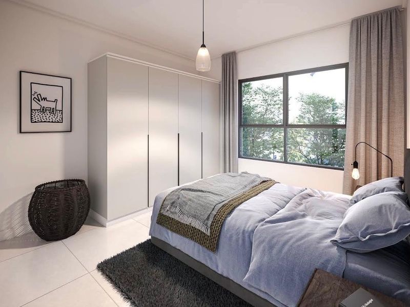 Modern bedroom featuring a large window, neutral tiled flooring, and a sleek built-in wardrobe with minimalist hardware.