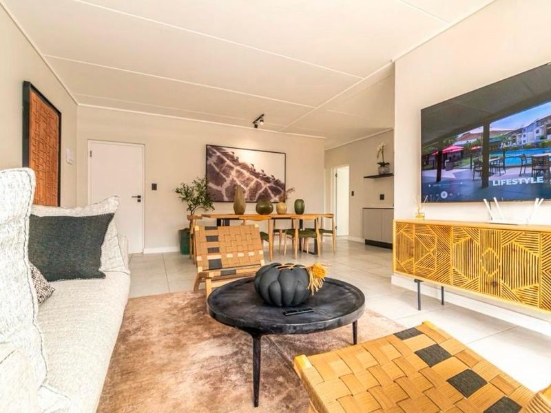 A bright open-plan living and dining area featuring neutral tiled flooring and a modern, clean layout suitable for contemporary apartment living.
