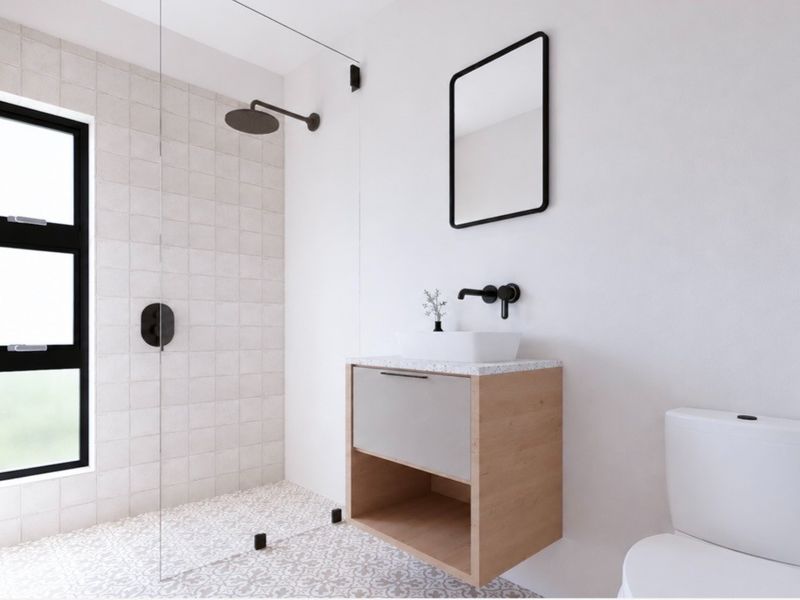 Modern bathroom featuring a walk-in shower with glass screen, wall-mounted vanity with vessel sink, and contemporary black matte fixtures.