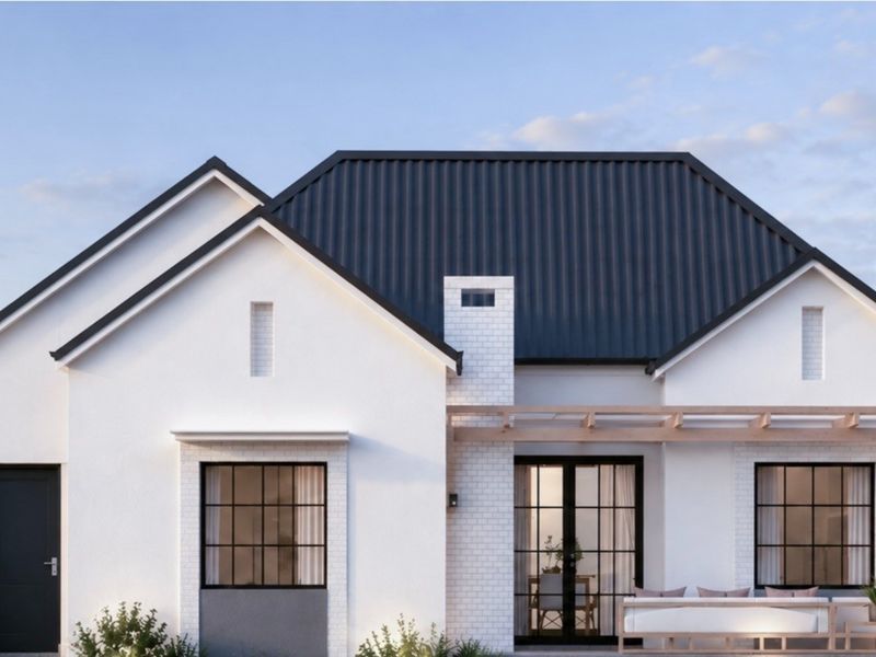A modern rear exterior view of a retirement village residence featuring a dark metal roof, timber pergola, and stylish black-framed windows and doors.