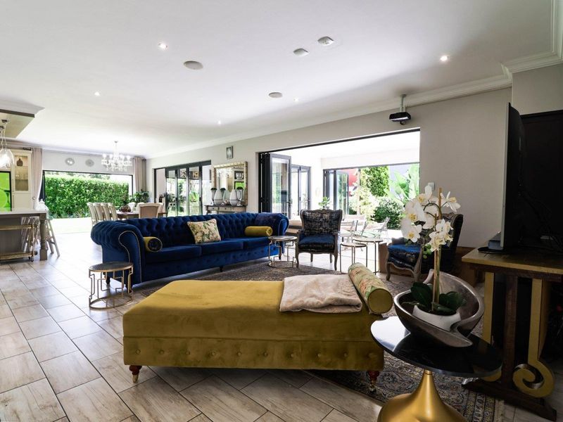 Spacious open-plan living area featuring tiled floors, recessed lighting, and large bi-fold doors that provide seamless access to the outdoor patio area.