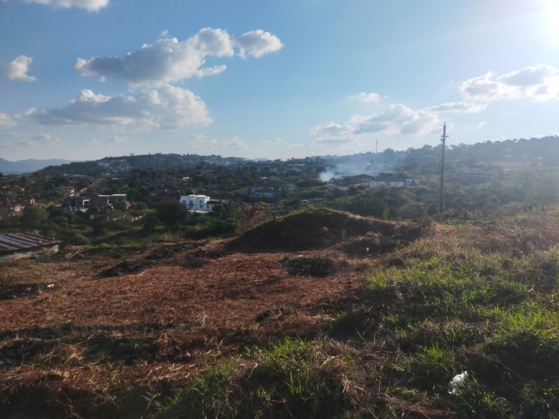 An elevated view overlooking a residential neighborhood and surrounding landscape from the vacant land plot.
