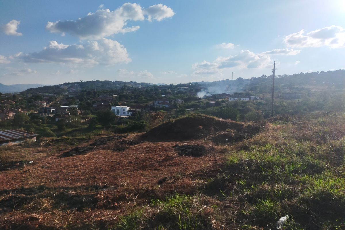 An elevated view overlooking a residential neighborhood and surrounding landscape from the vacant land plot.