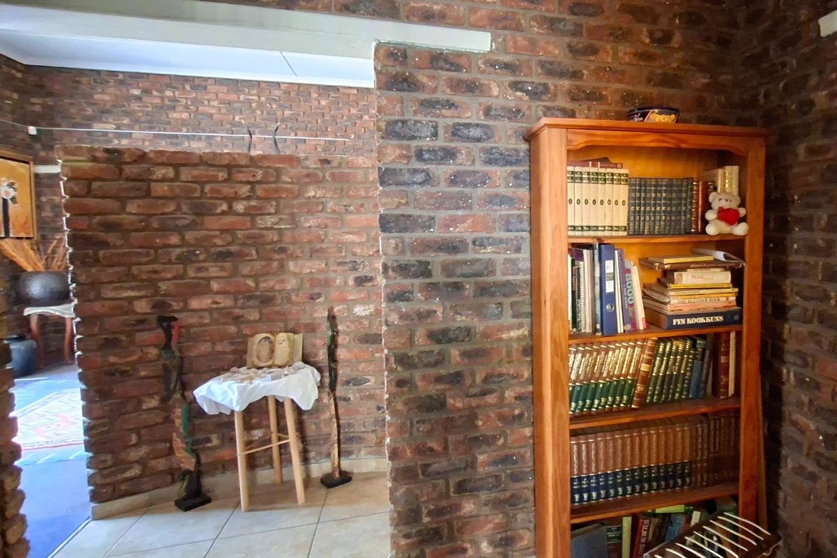 A living area featuring rustic exposed brick walls and neutral tiled flooring, providing a textured and character-filled space.
