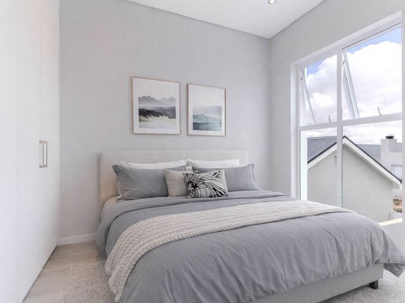 A modern, well-lit bedroom featuring built-in cupboards, neutral finishes, and a large window providing natural light and a view of the surrounding area.