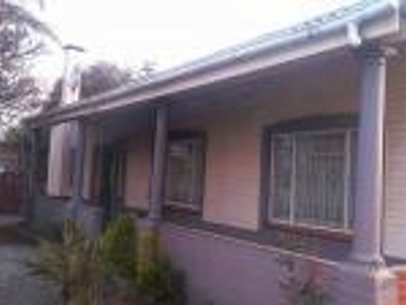 Front elevation of a house featuring a covered veranda with support columns and brick exterior wall finishes.