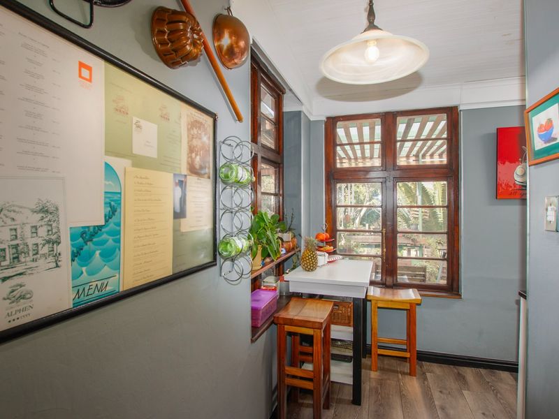A cozy kitchen nook featuring timber-framed windows, laminate flooring, and classic pendant lighting, offering a warm and functional space.