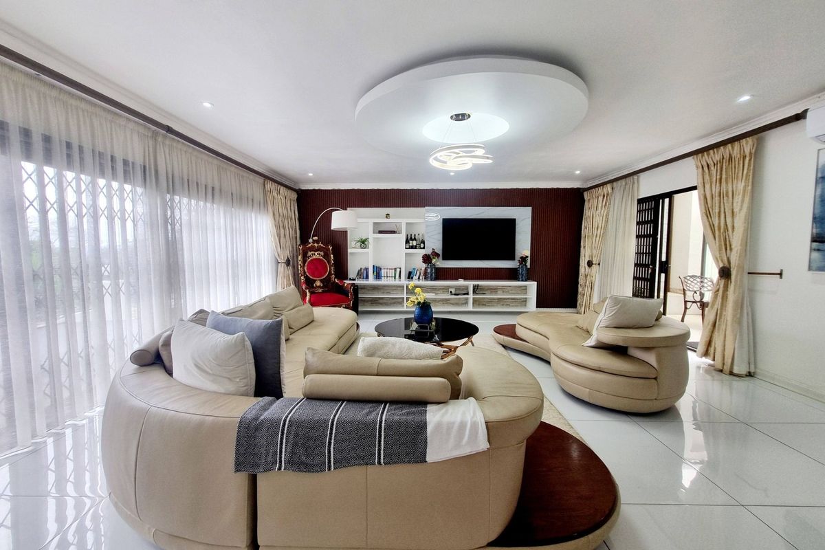 Spacious living room featuring a modern recessed ceiling design, built-in media cabinetry, and large sliding glass doors that provide ample natural light.