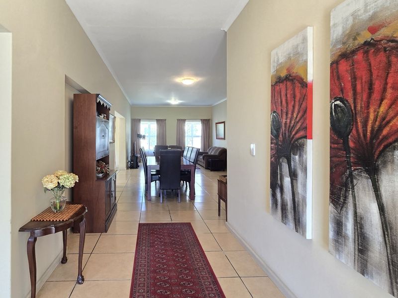 A spacious hallway featuring neutral wall tones and ceramic floor tiles, leading directly into the open-plan dining and living area.