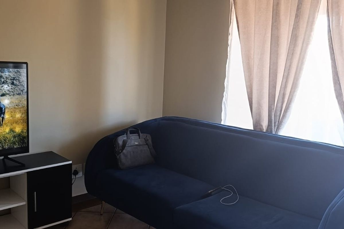 A living room area featuring tiled flooring and a sliding door providing natural light.