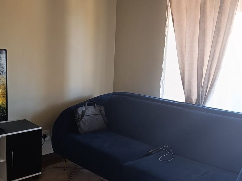 A living room area featuring tiled flooring and a sliding door providing natural light.