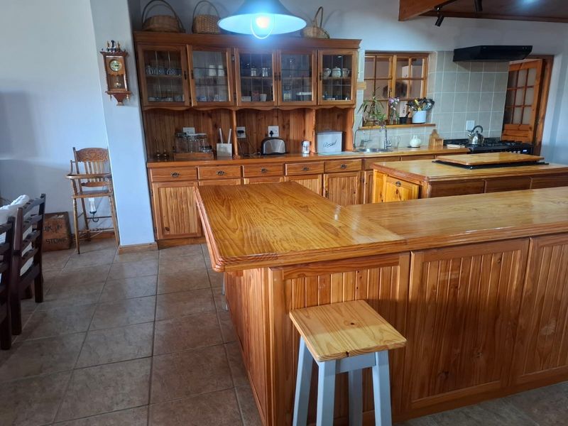 Spacious kitchen featuring extensive timber cabinetry, a large central island with timber countertops, and tiled flooring throughout.