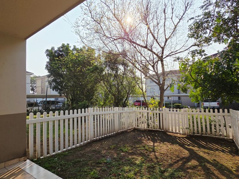 A ground-floor patio area featuring a white picket fence and a small private garden space.