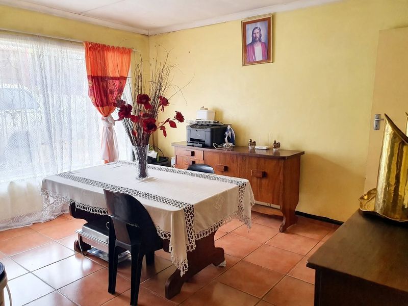A dining room featuring tiled flooring and a sliding glass door, providing access to natural light.