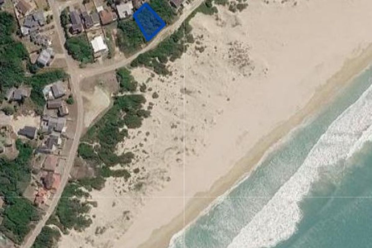 Aerial view of a vacant residential plot situated in a prime coastal location with direct proximity to the beach.