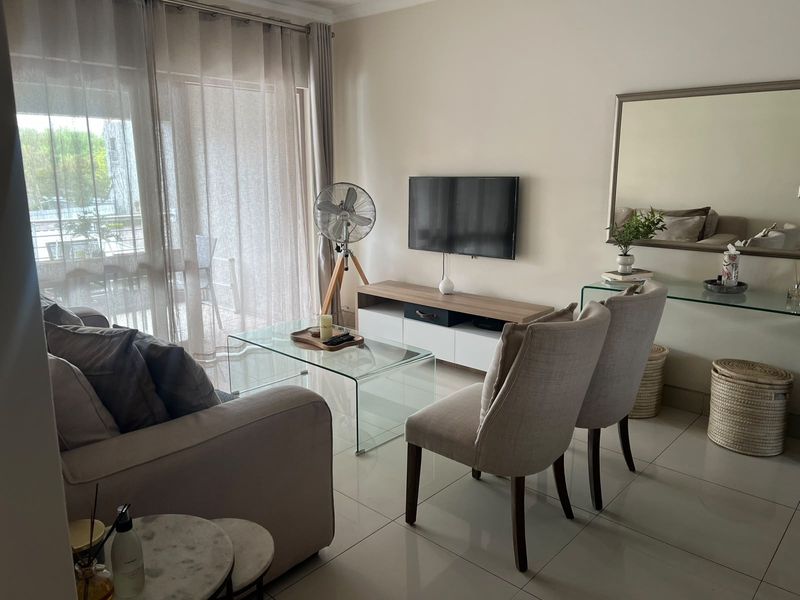A bright and modern living room featuring large sliding glass doors that provide natural light and access to the balcony.