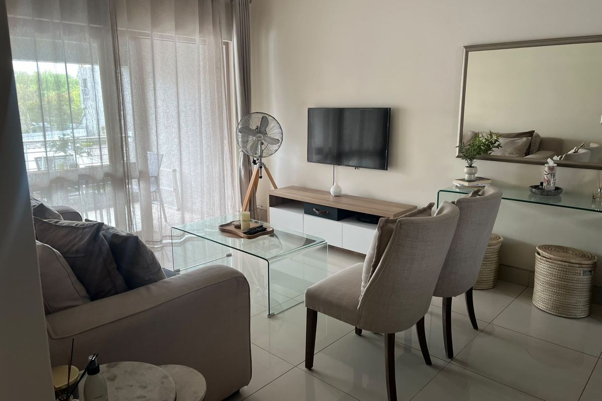 A bright and modern living room featuring large sliding glass doors that provide natural light and access to the balcony.