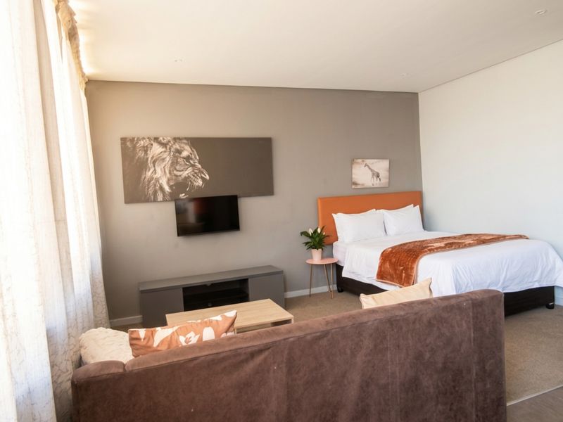 A well-maintained bedroom featuring neutral wall tones, recessed downlighting, and carpeted flooring, providing a comfortable and functional living space.