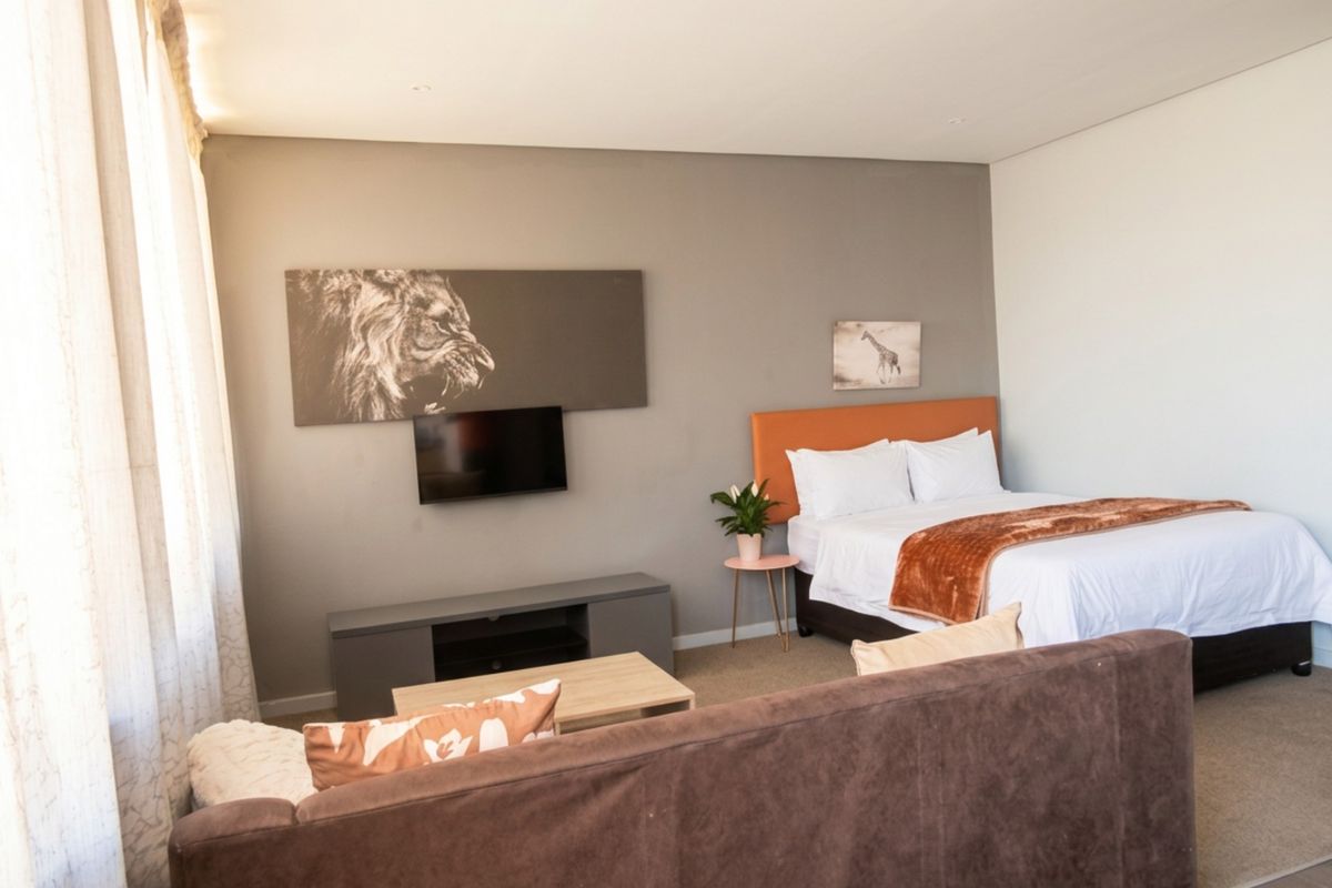 A well-maintained bedroom featuring neutral wall tones, recessed downlighting, and carpeted flooring, providing a comfortable and functional living space.
